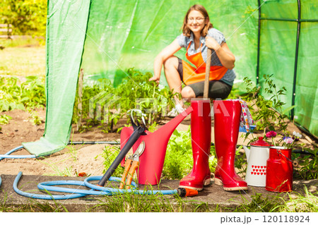 Female farmer and gardening tools in garden 120118924