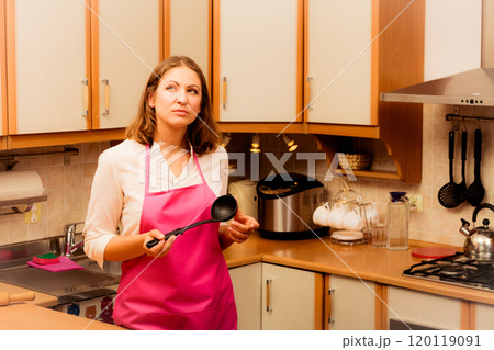 Housewife with ladle in kitchen Housewife with ladle in kitchen 120119091