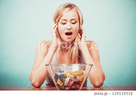 Diet. Girl with colorful measuring tapes in bowl 120119318
