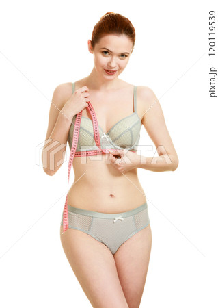 Woman measuring her under breasts. 120119539