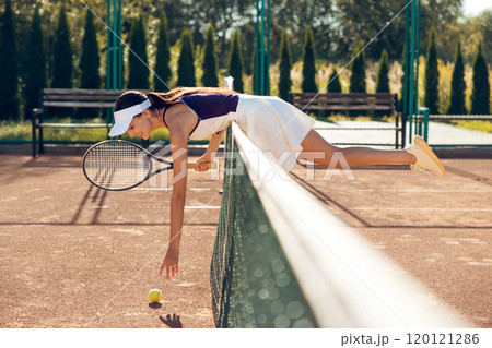 Female tennis player looking excited while having a workout on the tennis courts Female tennis player looking excited while having a workout on the tennis courts 120121286