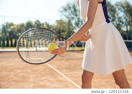 Female tennis player in white clothes exercising on the tennis courts 120121316