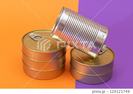 A Group of Stacked Tin Cans with Blank Edges on Split Orange and Violet Background A Group of Stacked Tin Cans with Blank Edges on Split Orange and Violet Background 120121749