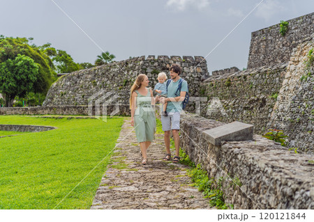 Mom, dad and their baby son exploring Fuerte de San Felipe de Bacalar. Family travel, cultural heritage, and historical adventure concept 120121844