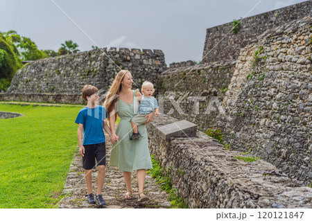 Mother with her toddler and teenage sons exploring Fuerte de San Felipe de Bacalar. Family travel, cultural heritage, and historical adventure concept 120121847