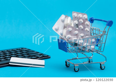 Ordering Medicines. Pills and Capsules in a Shopping Cart on Blue Background Ordering Medicines. Pills and Capsules in a Shopping Cart on Blue Background 120122030