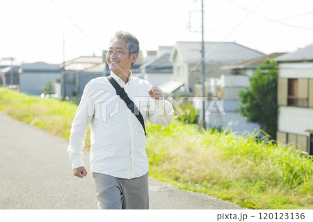 土手を元気にウォーキングするシニア　　 120123136