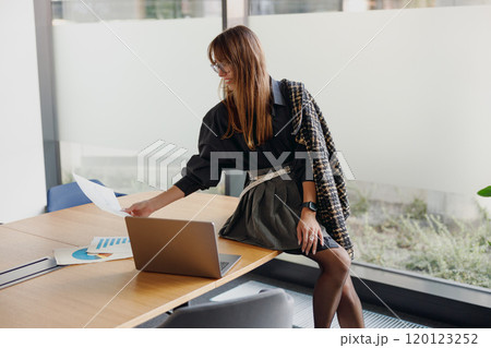 A Professional Woman Engaged in Her Work Within a Contemporary Office Environment 120123252