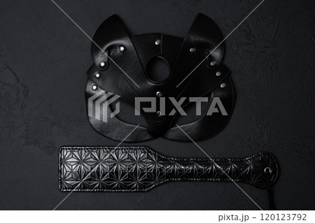 Black leather mask and adult toy on a white background, top view 120123792