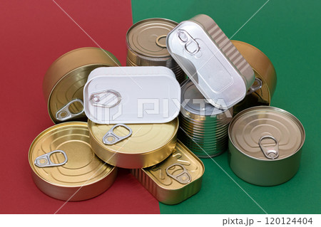 A Group of Stacked Tin Cans on Split Red and Green Background 120124404