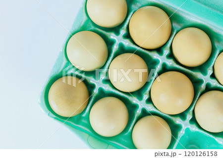 One dozen yellow eggs nestled neatly in an egg carton ready to be used for cooking baking One dozen yellow eggs nestled neatly in an egg carton ready to be used for cooking baking 120126158