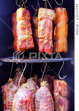 It is culinary tradition comprised of various cuts meat smoked a smoker bacon hung on hooks that creates delicious treat in smokehouse 120127554