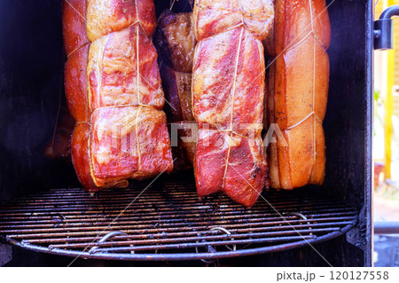 Cooking tradition various cuts of in smoker, bacon hung from hooks racks to produce delicious meal in smokehouse Cooking tradition various cuts of in smoker, bacon hung from hooks racks to produce delicious meal in smokehouse 120127558