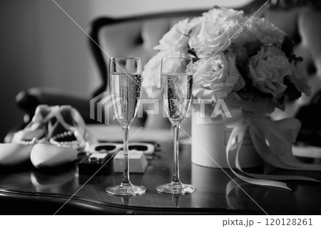 A black and white photo of a table with champagne and flowers 120128261
