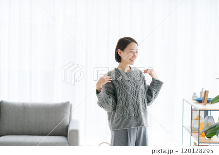 部屋でくつろぐミドル女性 120128295
