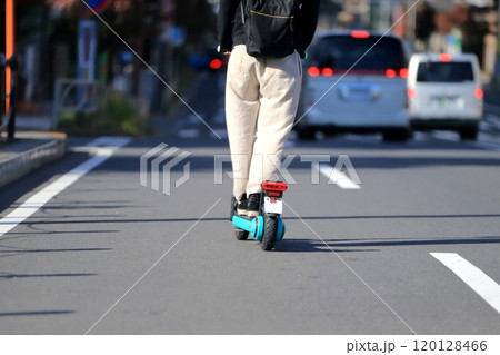 路上を走行中の電動キックボード 路上を走行中の電動キックボード 120128466