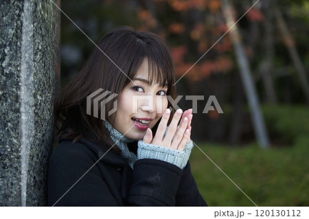 大阪府大阪市都島区の桜之宮公園で寒そうに息で手を温めている若い女性 120130112