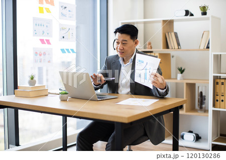 Asian businessman in headset presenting during virtual meeting 120130286