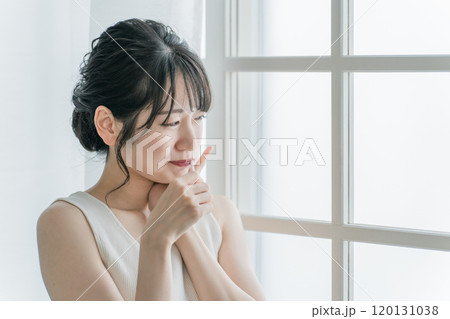 虫歯が痛い・しみて頬を押さえるアジア人女性 虫歯が痛い・しみて頬を押さえるアジア人女性 120131038