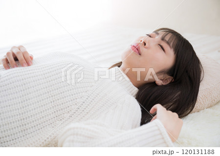 仰向けで目を閉じる女性 お昼寝や睡眠のイメージ 仰向けで目を閉じる女性 お昼寝や睡眠のイメージ 120131188