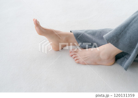 床に寝転ぶ女性の足元 120131359