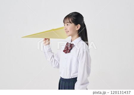白背景,大きい紙飛行機を飛ばす日本人女子中学生 120131437