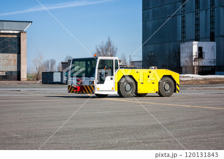 Aircraft tow tractor moves beside to the hangars 120131843