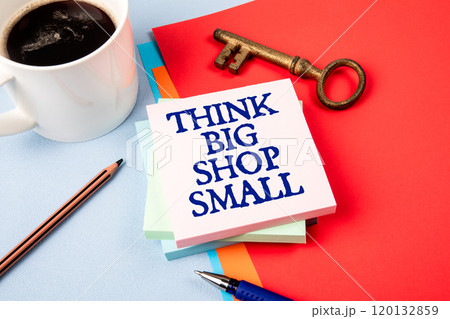 Think Big Shop Small. Notepad with text, coffee mug and golden key on office table 120132859