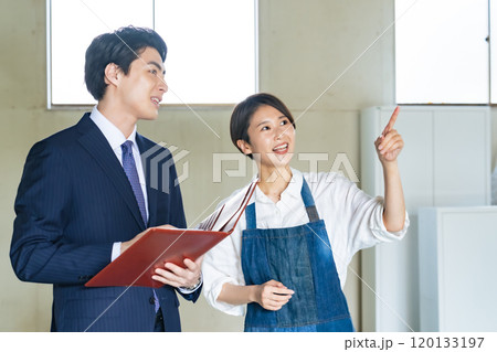 中古物件の内見をする店舗経営する女性と営業マン 120133197