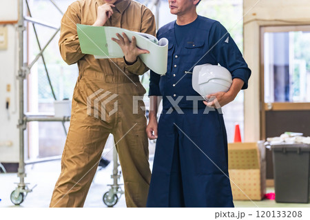 工事現場で相談する大工と作業員 工事現場で相談する大工と作業員 120133208