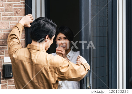 住宅に押し入る男性と驚く女性住民 120133223