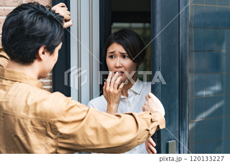 住宅に押し入る男性と驚く女性住民 120133227