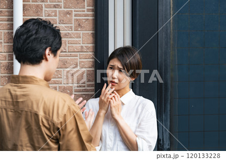 玄関で業者から説明を受け怖がる女性住民 玄関で業者から説明を受け怖がる女性住民 120133228