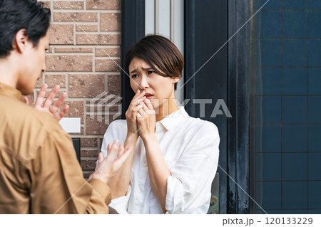 玄関で業者から説明を受け怖がる女性住民 120133229