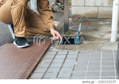 水道メーターを確認する作業員 120133237