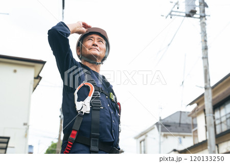 住宅街に立つシニア作業員 住宅街に立つシニア作業員 120133250