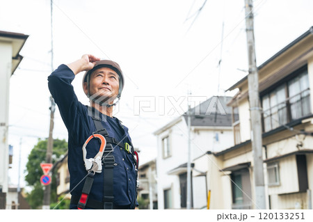 住宅街に立つシニア作業員 住宅街に立つシニア作業員 120133251
