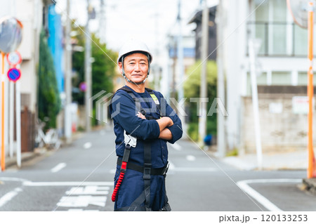 住宅街に立つシニア作業員 120133253