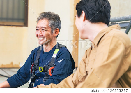 工事現場で談笑する大工と作業員 工事現場で談笑する大工と作業員 120133257