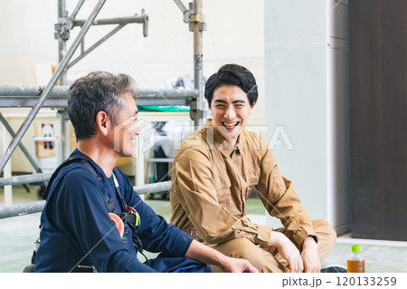 工事現場で談笑する大工と作業員 工事現場で談笑する大工と作業員 120133259