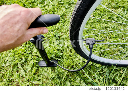 Inflating bicycle tire using floor pump with presta and schrader valve adaptor. 120133642