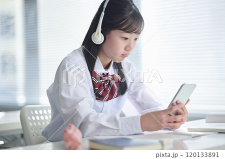 スマートフォンで授業を受ける女子中学生 120133891