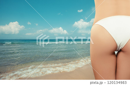 Woman hip in white bikini on the sea and sand beach background Woman hip in white bikini on the sea and sand beach background 120134983