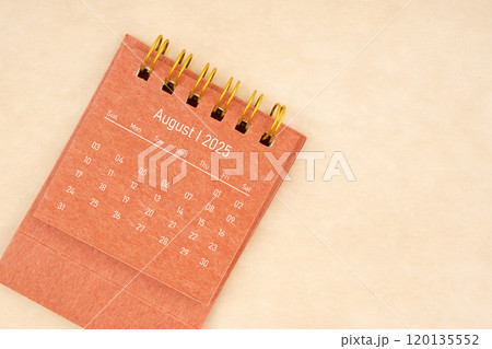 Mini red desk calendar for August 2025 year on old brown paper background. Mini red desk calendar for August 2025 year on old brown paper background. 120135552