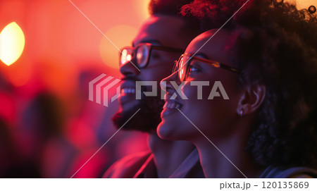A couple enjoying a vibrant concert atmosphere with colorful lights in a lively urban venue during a music event 120135869