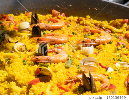 Seafood paella, Spanish rice dish with shrimp, mussels, clams, yellow rice in large pan close up 120136569