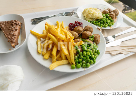 Meatballs with french fries, green peas, bechamel sauce and cranberry jam, meat balls on white plate Meatballs with french fries, green peas, bechamel sauce and cranberry jam, meat balls on white plate 120136823