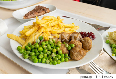 Meatballs with french fries, green peas, bechamel sauce and cranberry jam, meat balls on white plate Meatballs with french fries, green peas, bechamel sauce and cranberry jam, meat balls on white plate 120136825