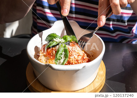 Lasagna portion, oven baked lasagne, pasta layers with cheese, minced meat, tomato in sunny summer day Lasagna portion, oven baked lasagne, pasta layers with cheese, minced meat, tomato in sunny summer day 120137240