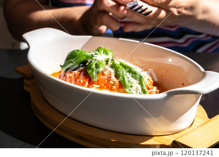 Lasagna portion, oven baked lasagne, pasta layers with cheese, minced meat, tomato in sunny summer day 120137241